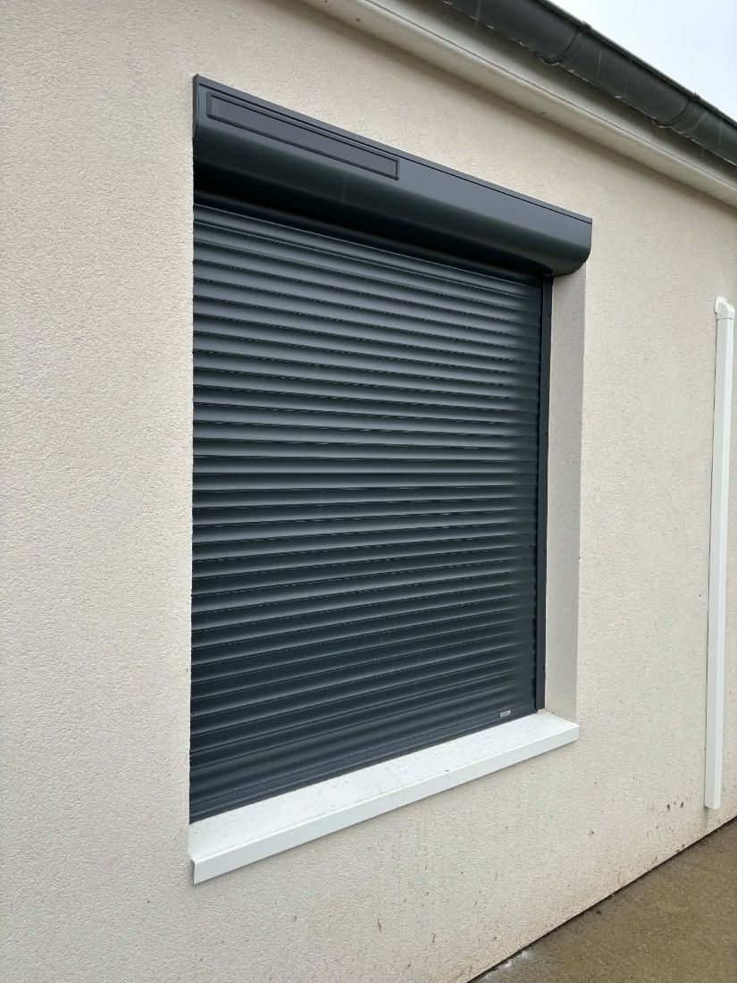 Volet roulant gris anthracite fermé sur une façade crépie