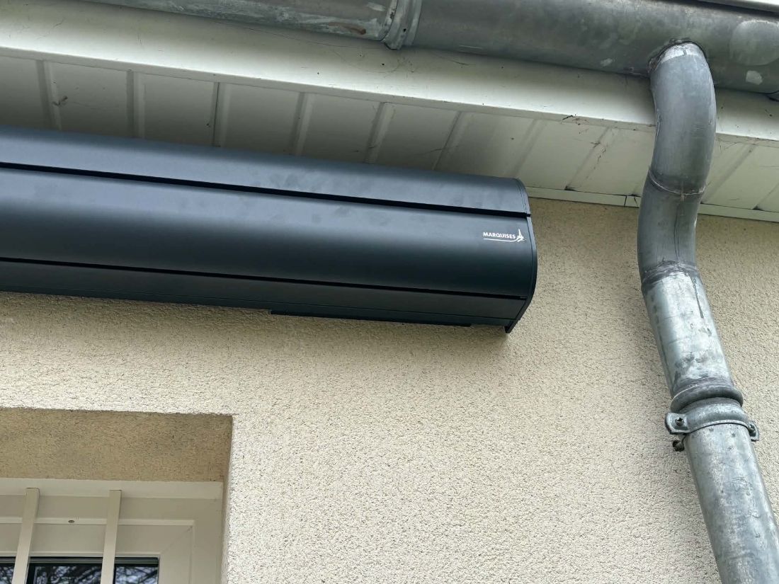 Coffre de volet roulant gris anthracite sous une gouttière
