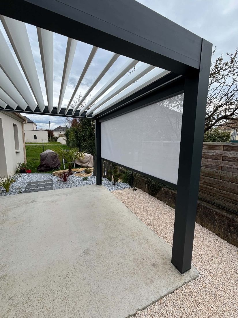 Pergola à lames orientables avec store latéral déroulé